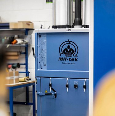 How does a cardboard baler operate?