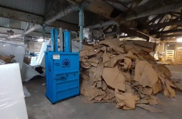 Blue baler and large pile of cardboard at Westieri Beds