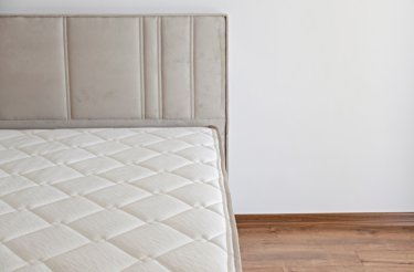 Partial view of a bed from Westieri Beds in an empty room with wooden floors